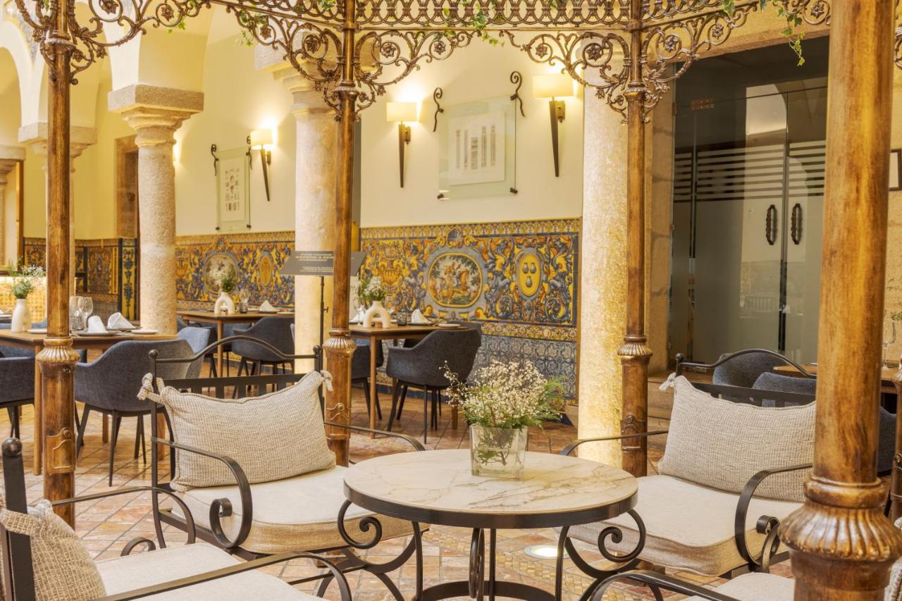 伊露尼翁梅里达宫酒店 外观 照片 The photo depicts a charming café or restaurant setting. The space features ornate ironwork columns and decorative tile work on the walls, adding a touch of elegance. The furniture includes cozy, cushioned seating arranged around small tables. Some t